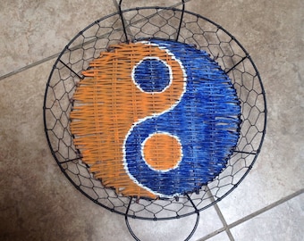 Ying Yang symbol painted basket in Denver Bronco colors. Repurposed yardsale basket into fun Denver Bronco Art
