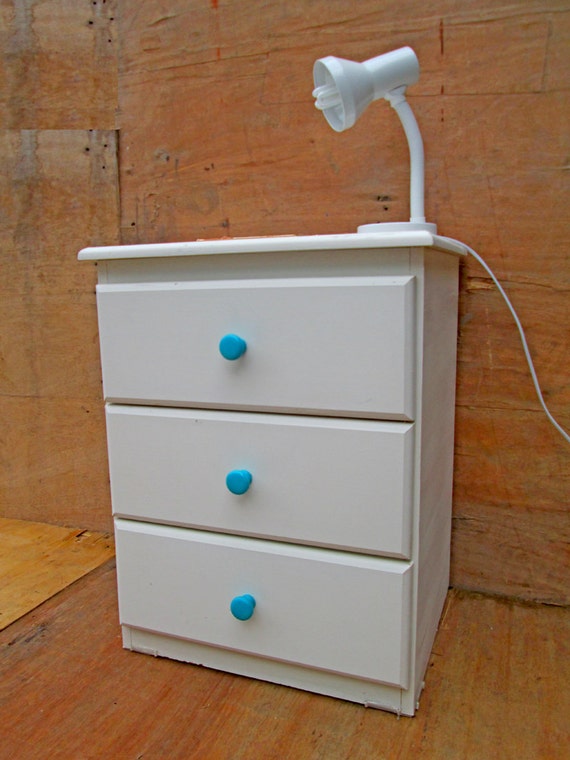 white wooden bedside table with turquoise knobs. childrens