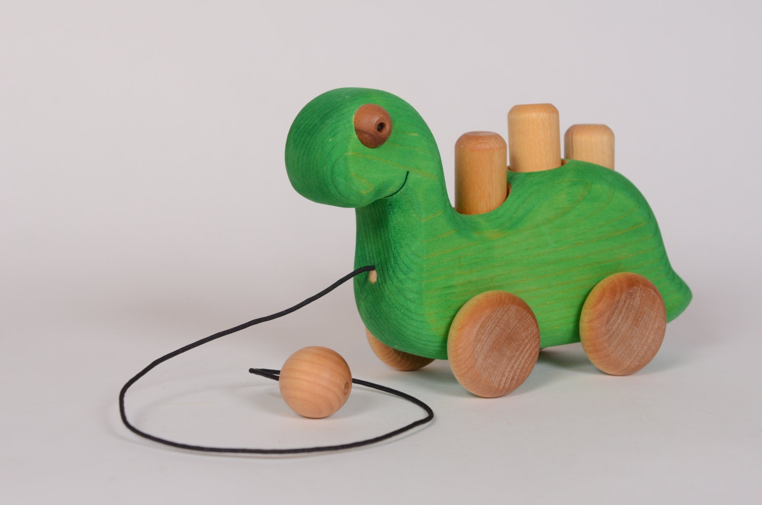 Green wooden dinosaur pull toy by by LAtelierChevaldeBois on Etsy