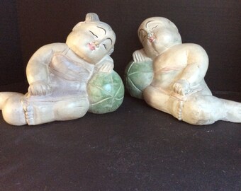 Carved pair of Asian children napping on a melon