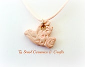 Pink ceramic dove pendant on a pink cord.