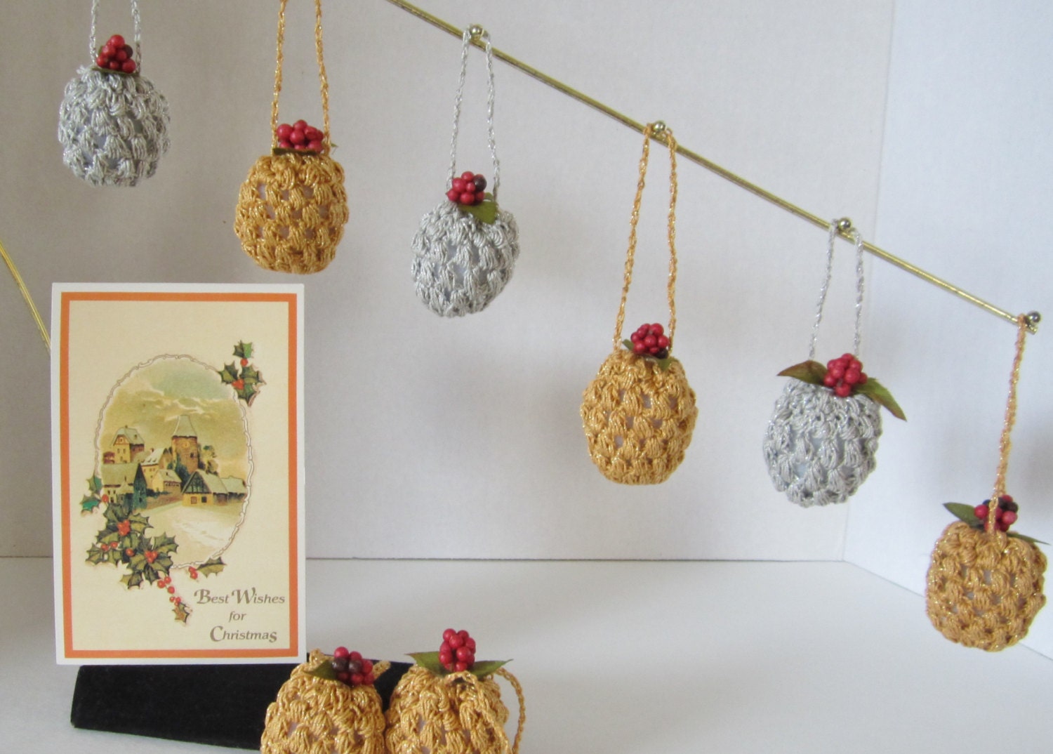 Christmas Ornaments - these petite pinecone ornaments are crochet with gold glitter yarn and embellished with green leaves & red berries.