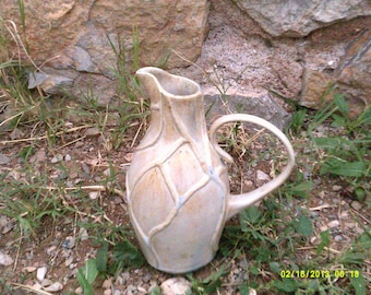 white ceramic pottery pitcher with crystalline glaze and raised pattern