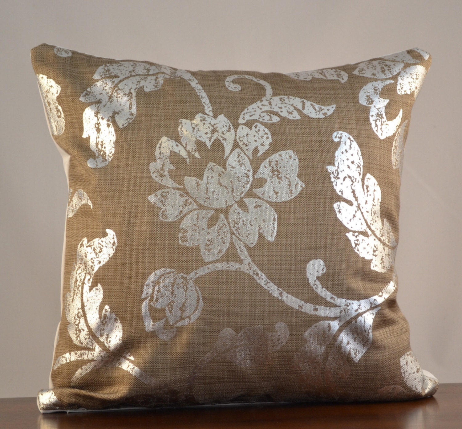 Decorative metallic silver pillow cover with a flowered