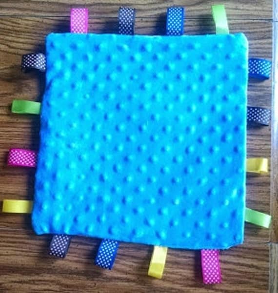 Taggie Blanket for baby. Stimulates senses and helps develop fine motor skills.