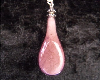Purple glass bottle pendant with glow in the dark crystal contents on silver chain
