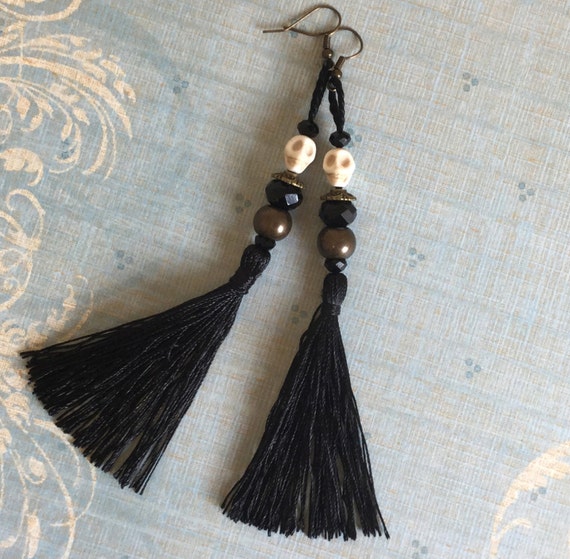 Voodoo doll, black tassel, skull earrings.