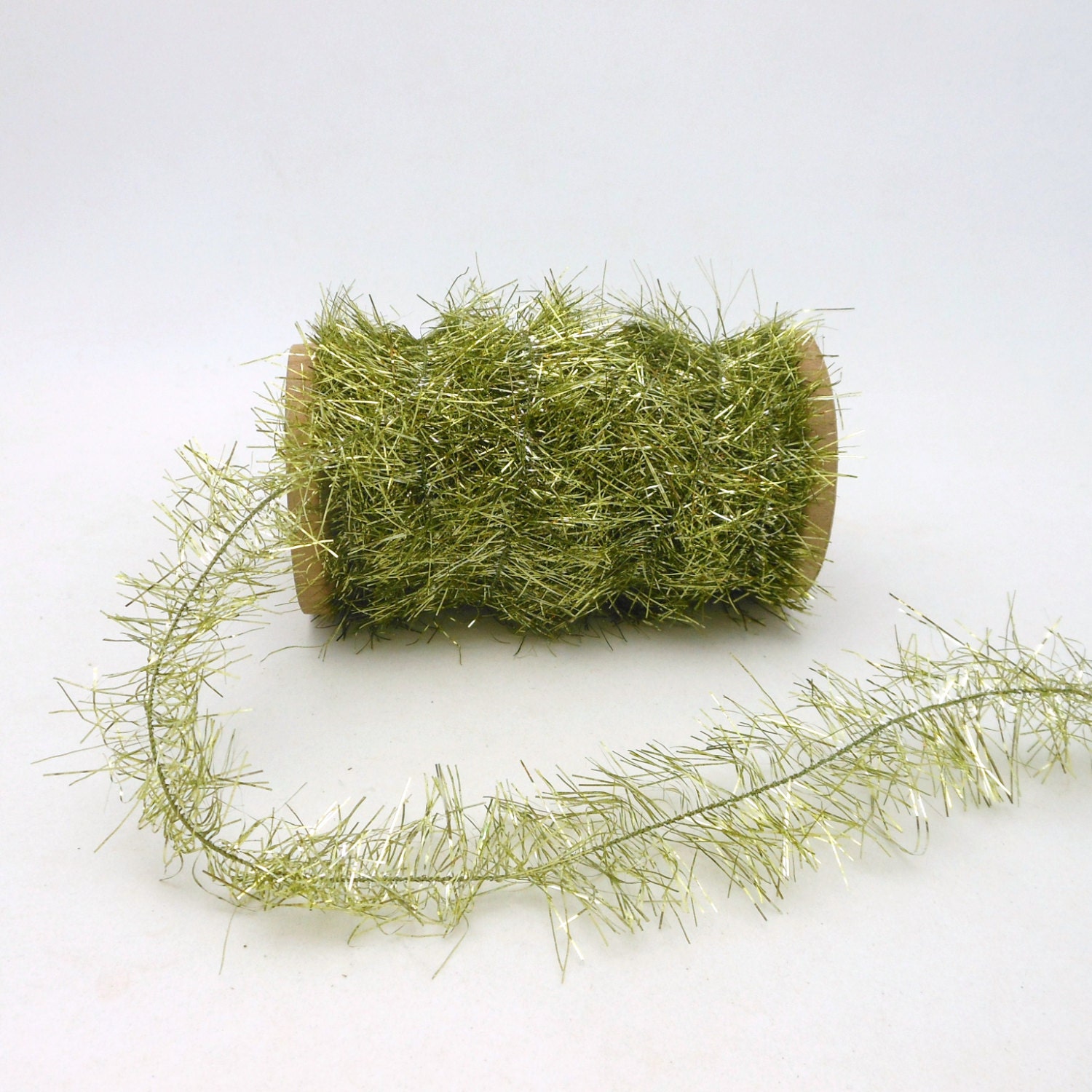 light green tinsel garland on wooden spool by light green tinsel garland on wooden spool by