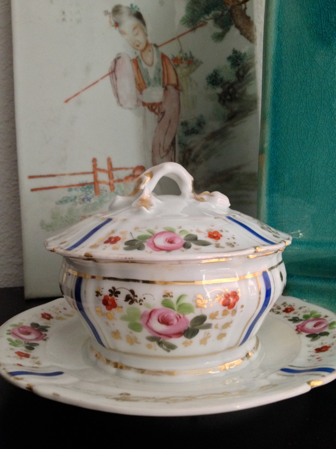 hand painted covered bowl with attached footed plate. gold, indigo