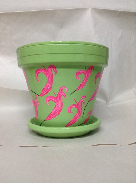 Hand painted green flowerpot with hot pink flowers. Garden