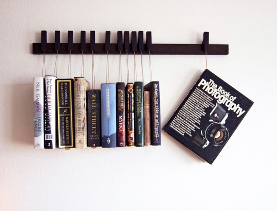 Custom made wooden book rack / bookshelf in Wenge. Pins also work as bookmarks. Bookcase