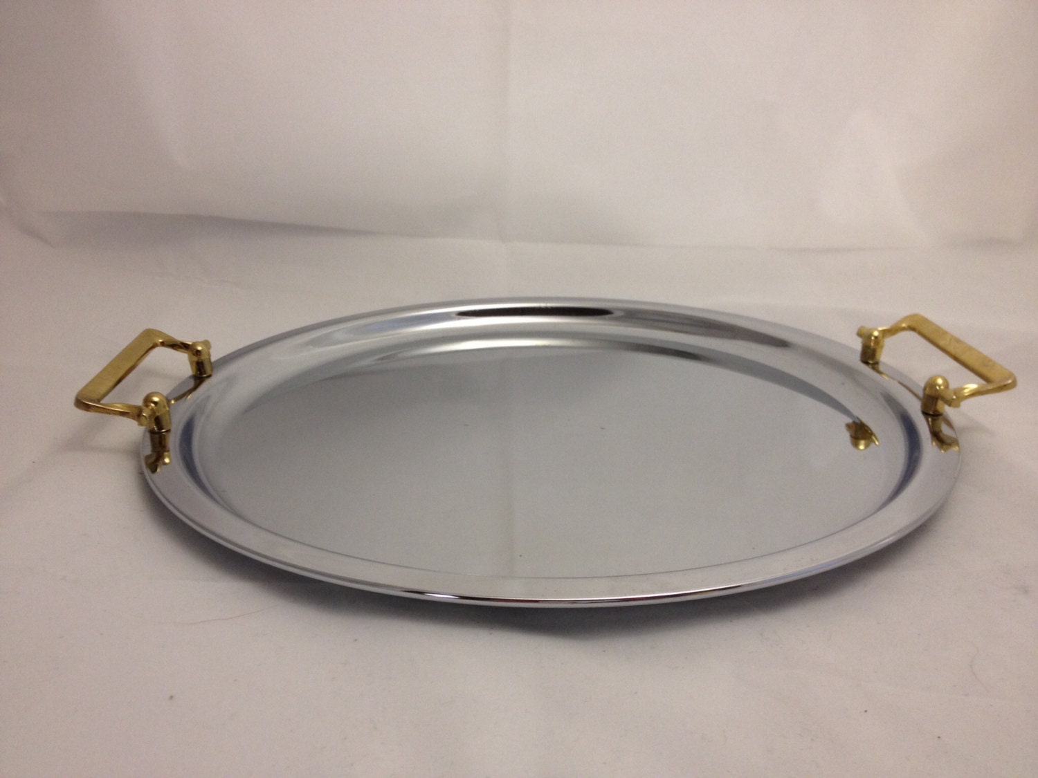 Midcentury modern round chrome serving tray with two handles. Haute