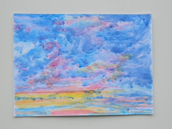 Blue clouds in the sky darkened, with sunset of colors.