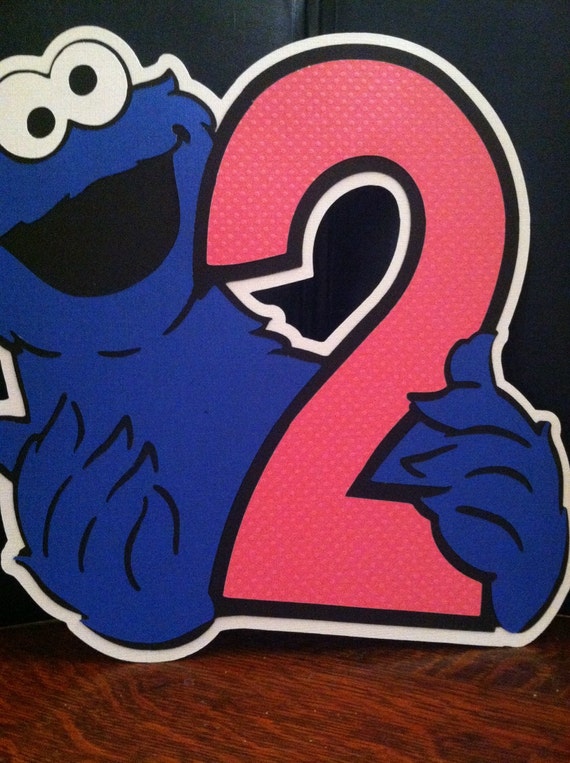 sesame streets cookie monster with the number 2 sign for