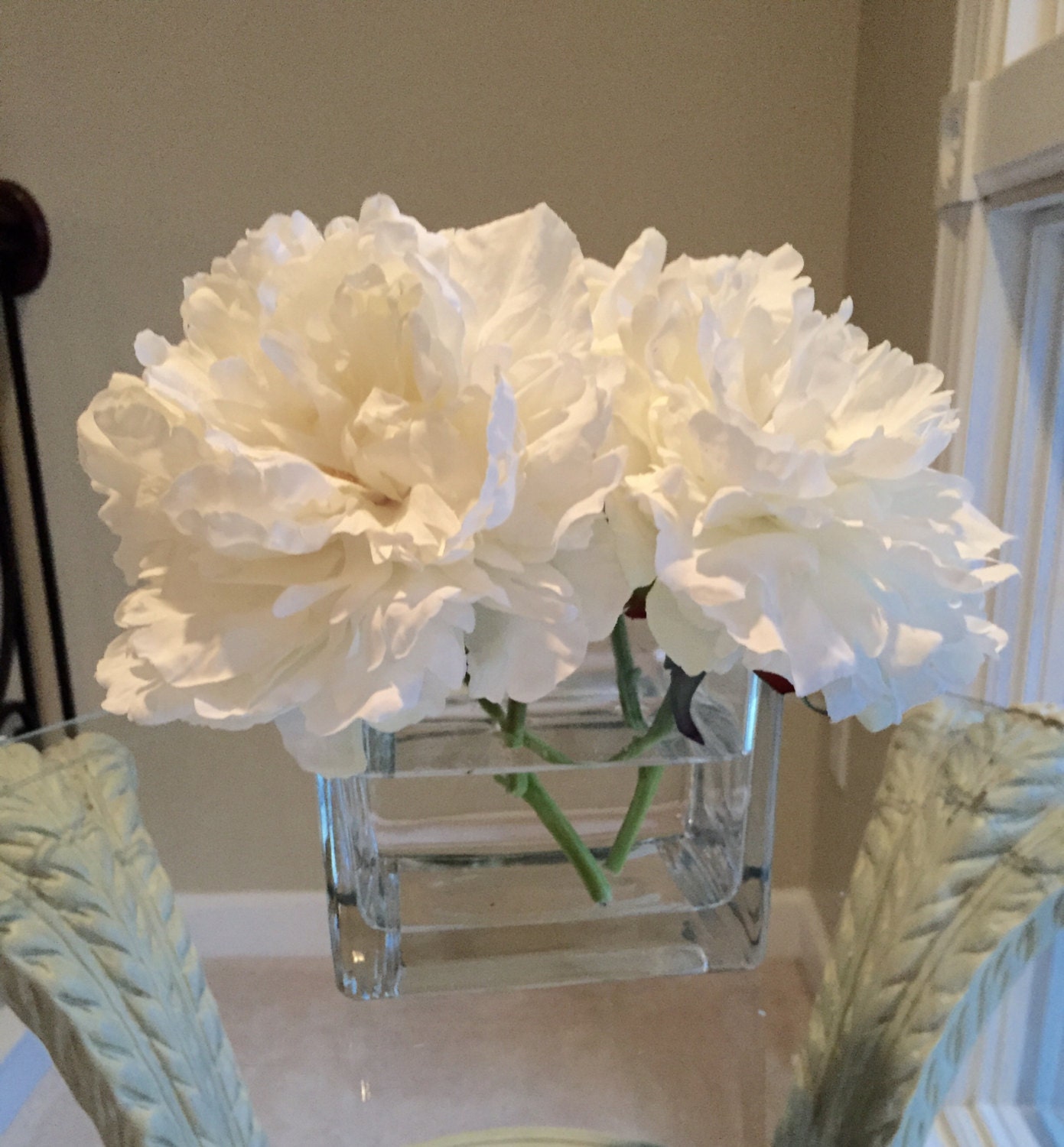 Beautiful white peonies in glass vase with acrylic water