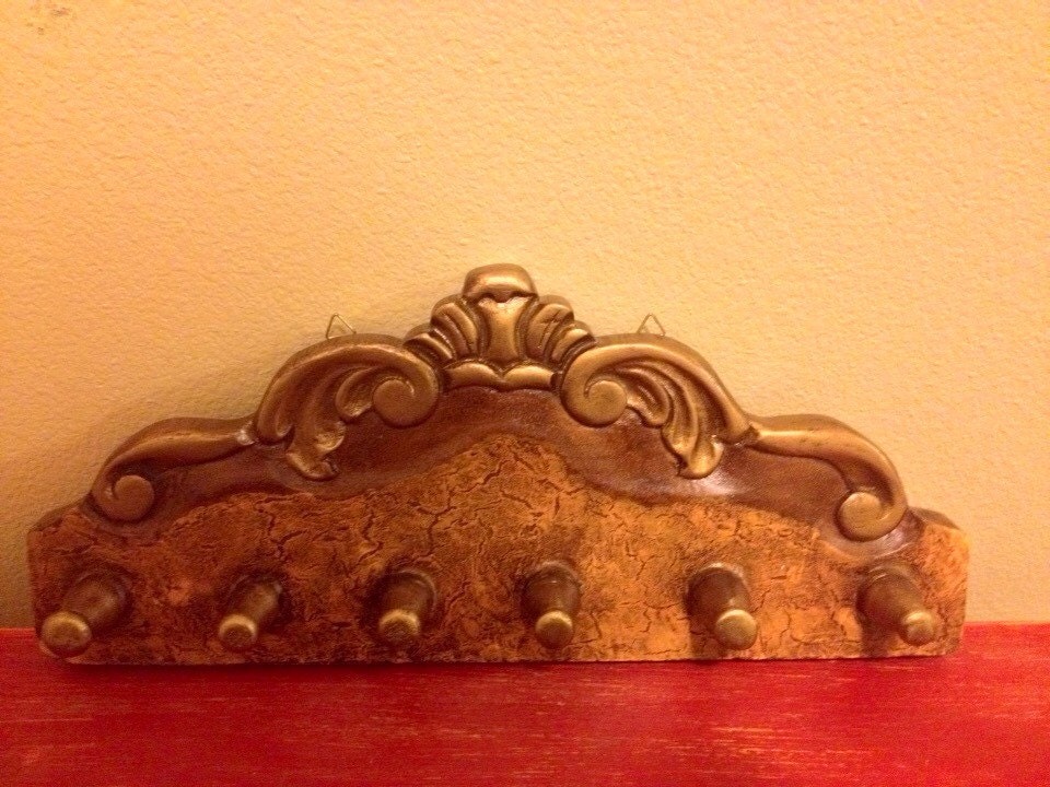 Hand carved wooden hanger in a rich gold tone colors. Haute Juice