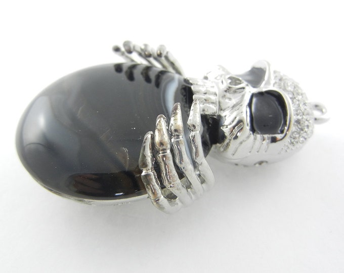 Silver-tone Dimensional Skull Holding Acrylic Black Marble Disk Pendant