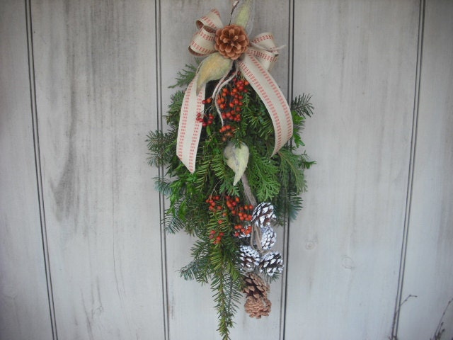 Evergreen Swag made with fresh Balsam, Pine, Cedar, and Boxwood. Decorated with rosehips, pine cones and burlap bow.