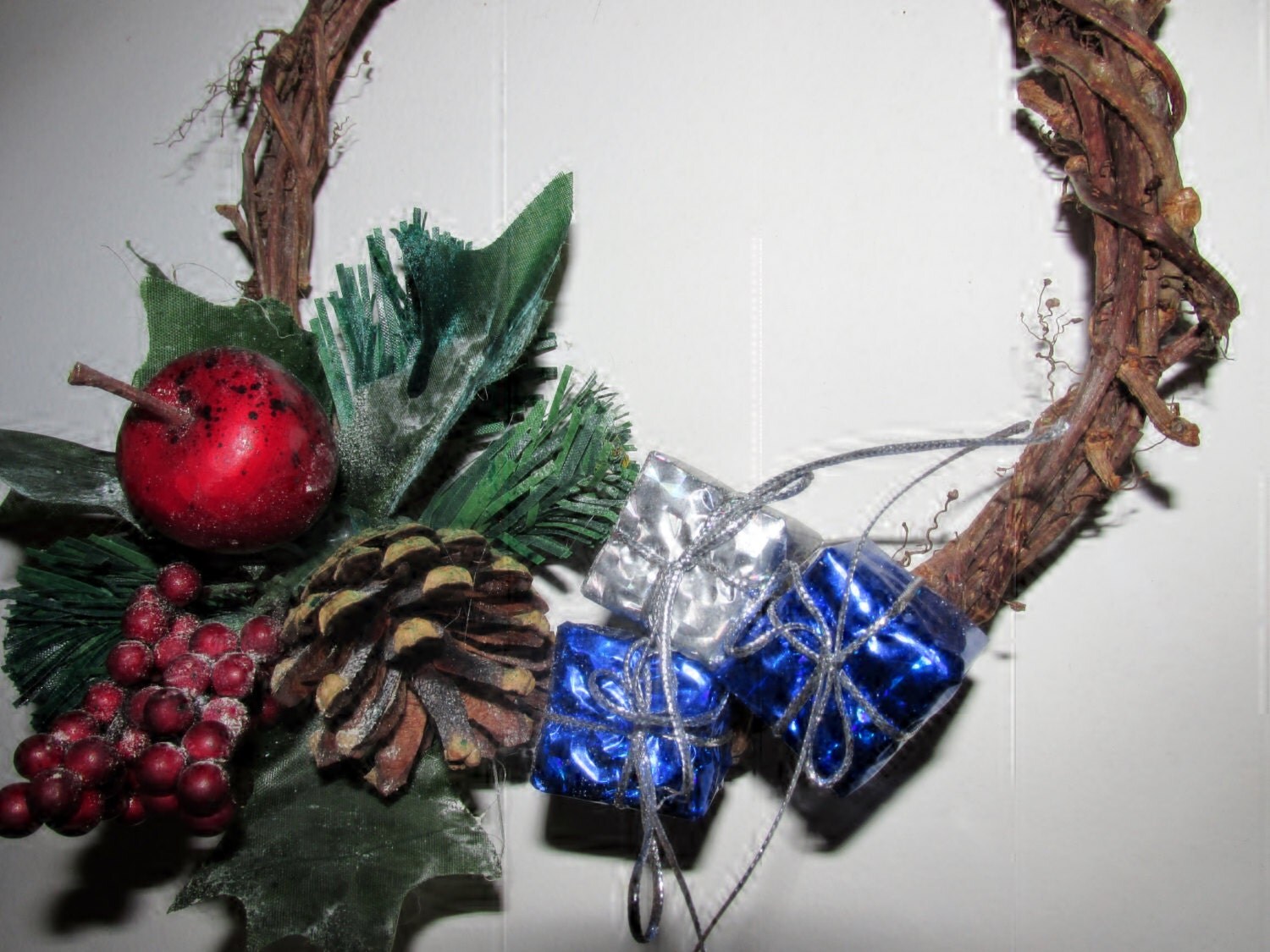 Hand weaved wreath of vines with blue and silver gift embellishments and silk greenery. Yule, wiccan, pagan