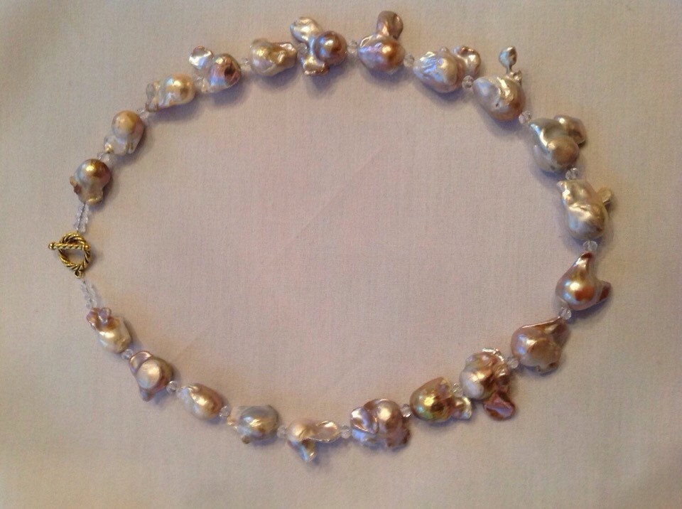 Long strand of large beige freshwater baroque pearls