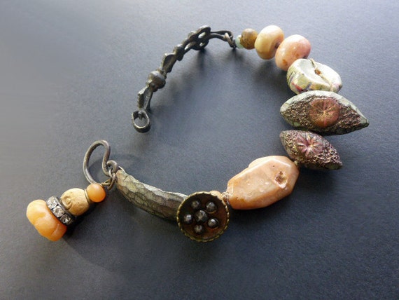 Visitors in the Universe.  Rustic assemblage bracelet with art beads in pale greens and peach.