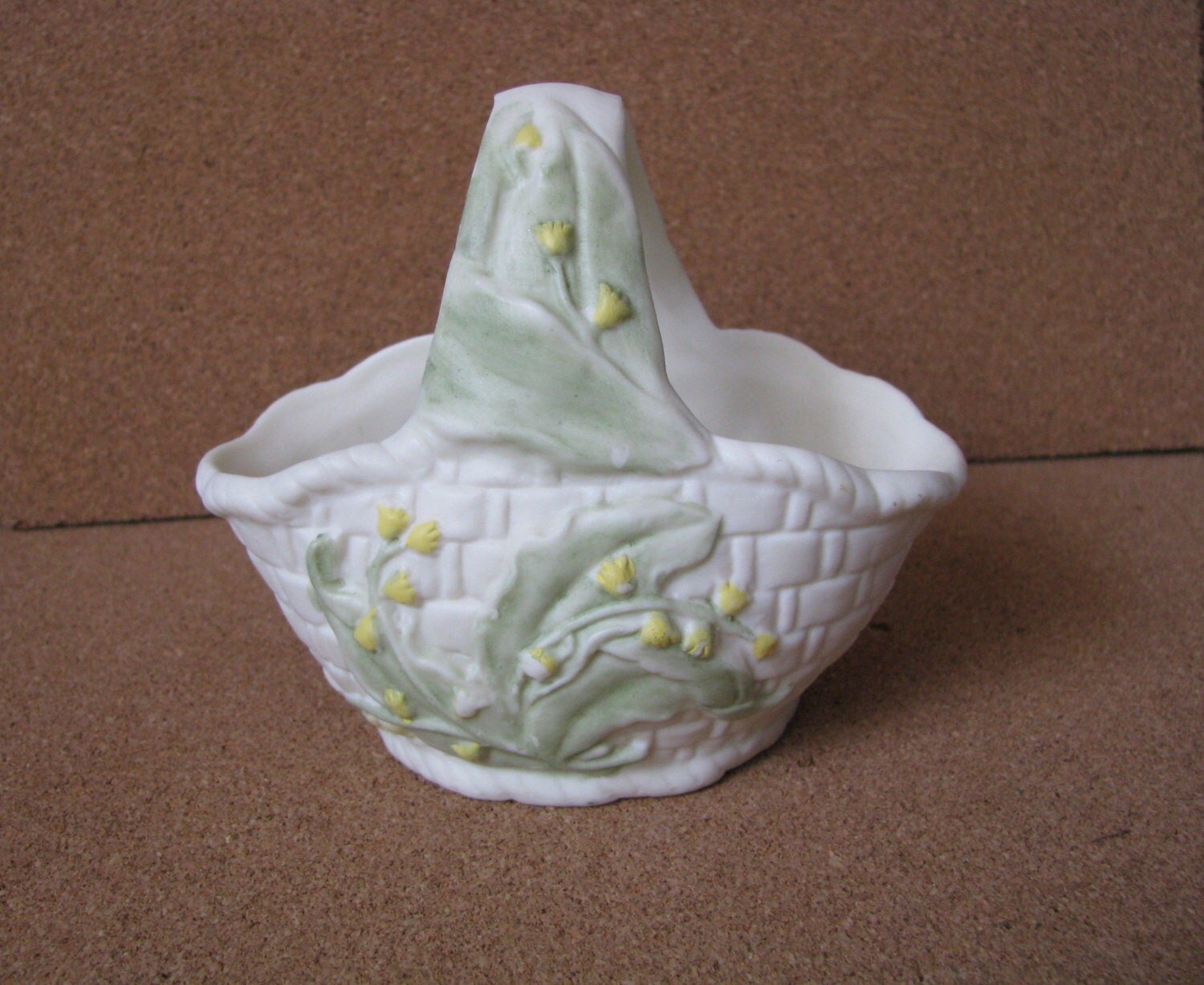 White ceramic basket with handle and yellow green flowers