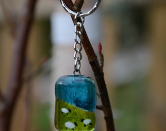 Gorgeous fused glass keyring. Blue skies and sheep grazing in the fields. Hand made.