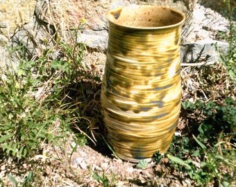 tall pottery utensil holder or vase lightly glazed in greenish brown with hints of blue
