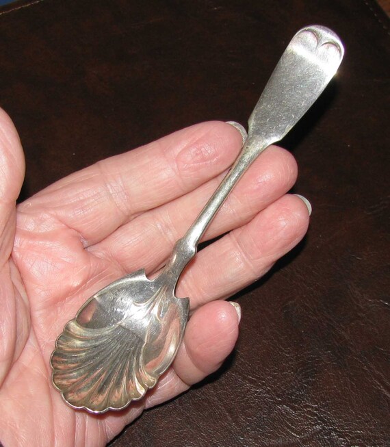 Antique silver sugar spoon with shell design