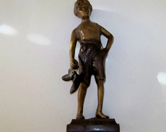 Metal Statue Of Boy Holding A Pair Of Shoes