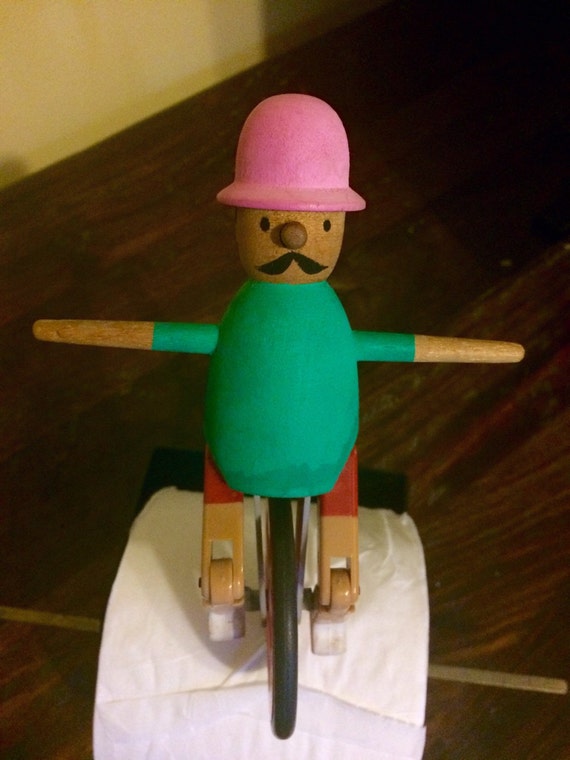 Whimsical toilet paper holder with man riding unicycle