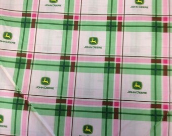 A John Deere fabric in two shades of pink and green plaid. Has the John Deere logo