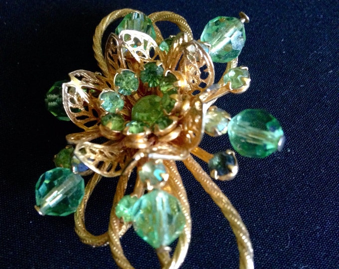 Storewide 25% Off SALE Vintage Oversized Gold Tone Circular Floral Style Ladies Brooch Featuring Faceted Emerald Green Rhinestone Accents.