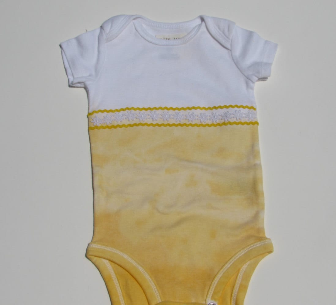 Yellow ombre dyed baby girl's onesie. Trimmed in by