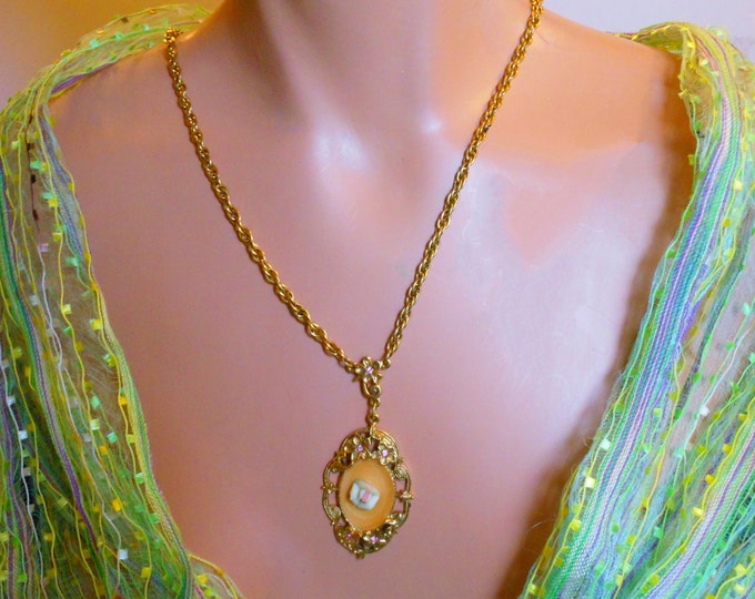 1928 necklace, butterscotch orange swirled enamel encloses standard 1928 pink porcelain rose, gold floral frame of pink rhinestone flowers
