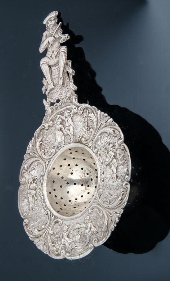 German 800 silver figural tea strainer