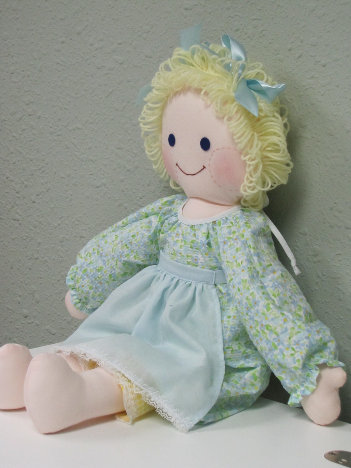 Rag doll with blond yarn hair and blue eyes comes with
