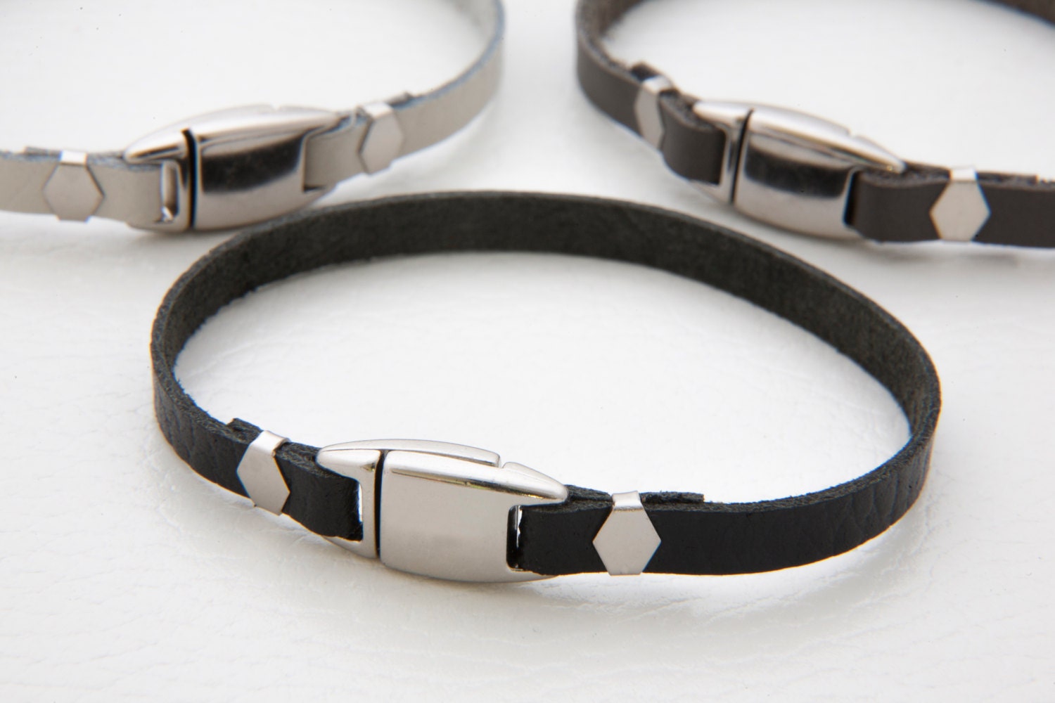 Thin leather bracelet with center piece clasp