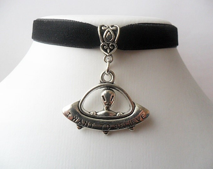 Black velvet choker necklace with i want to believe alien in spaceship ufo pendant and a width of 3/8”inch.
