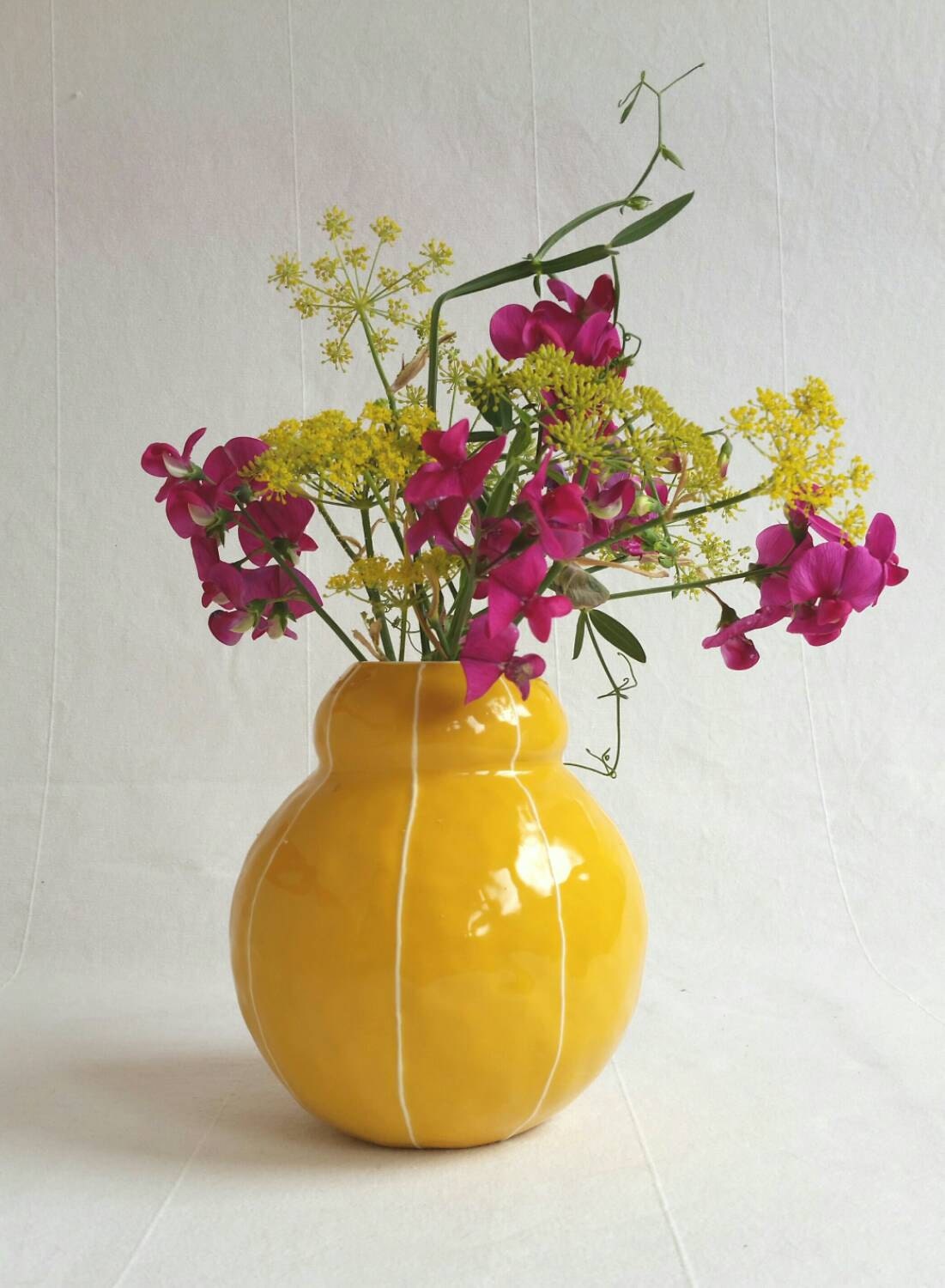 Ceramic vase bright yellow. Short round shape with white