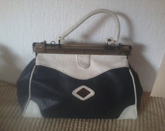 blue leather bag with navy and white on the side clasps