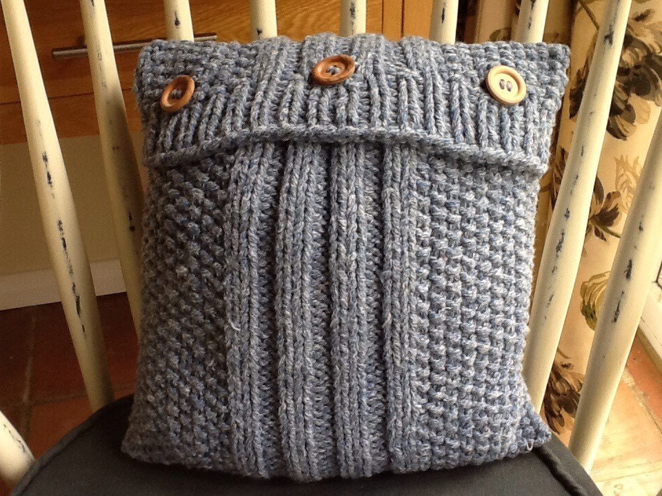Blue knitted cushion cover with moss stitch & rib border