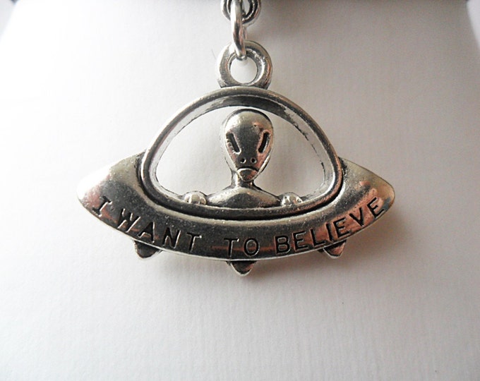 Black velvet choker necklace with i want to believe alien in spaceship ufo pendant and a width of 3/8”inch.