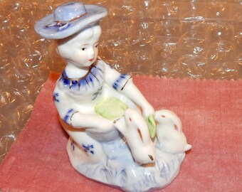 Girl Wearing Hat in Blue and Gold Petting and Feeding Rabbits Figurine