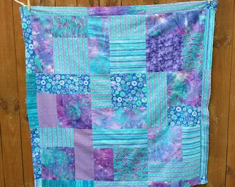 Batik unfinished quilt top, approx 48" x 48". Turquoise and lavenders.