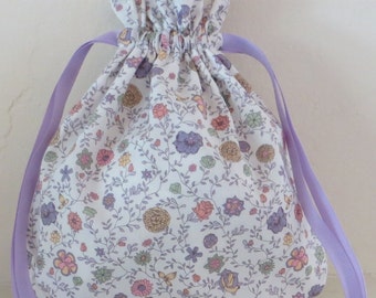 Liberty of London drawstring bag, floral design, lavender, pink, yellow, and green on white background