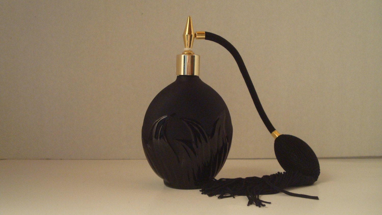 Vintage black on black perfume bottle with atomizer