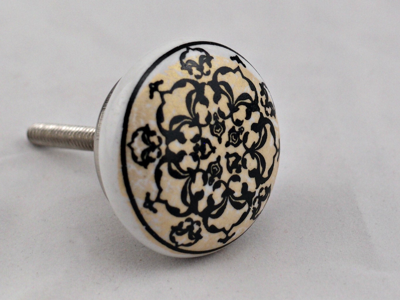 White round painted ceramic knob with black and gold design