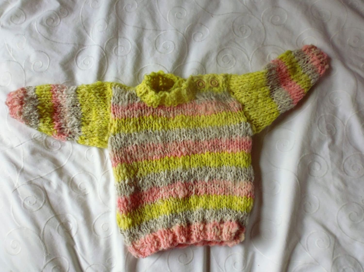 Hand knitted babies jumper using a mixture of hand spun alpaca