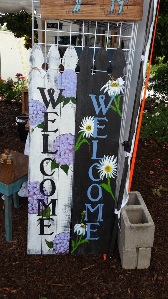 Large picket fence style sign with hand